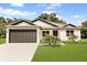 Charming single-story home with a well-manicured lawn, a two-car garage, and neutral-colored exterior at 321 Watershore Dr, Leesburg, FL 34748