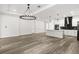 Open living space with modern lighting, an island with bar seating, and white cabinets, creating a cohesive design at 321 Watershore Dr, Leesburg, FL 34748