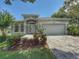 Charming single-story home featuring a two-car garage and beautifully landscaped front yard on a sunny day at 3416 Capland Ave, Clermont, FL 34711