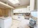Bright kitchen featuring white cabinets, island, neutral countertops, and ceramic tile backsplash, plus modern fixtures at 3416 Capland Ave, Clermont, FL 34711