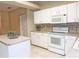 Kitchen featuring white cabinetry, stainless appliances, neutral countertops, and ceramic tile backsplash at 3416 Capland Ave, Clermont, FL 34711