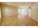 Bright living room with hardwood floors, neutral walls, a modern light fixture and view into kitchen area at 3416 Capland Ave, Clermont, FL 34711