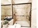 Modern shower features sleek glass doors, built-in shelves, and grab bars for safety at 3416 Capland Ave, Clermont, FL 34711