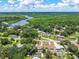 Scenic aerial view of a charming home in a lush, green community with a lake backdrop and sunny skies at 35338 Lake Unity Rd, Fruitland Park, FL 34731