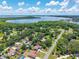 Scenic aerial view of a charming home in a lush, green community with a lake backdrop and sunny skies at 35338 Lake Unity Rd, Fruitland Park, FL 34731