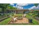 Backyard area with two Adirondack chairs centered around a gravel fire pit surrounded by a garden at 35338 Lake Unity Rd, Fruitland Park, FL 34731