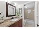 Bathroom featuring a granite countertop, framed mirror, and shower with a tile surround at 35338 Lake Unity Rd, Fruitland Park, FL 34731