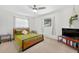 Cozy bedroom with a ceiling fan, green bedding, and bright natural light at 35338 Lake Unity Rd, Fruitland Park, FL 34731