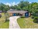 Inviting single-story home with a brick facade, blue accents, and a curved driveway at 35338 Lake Unity Rd, Fruitland Park, FL 34731