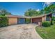 Exterior of the house showing the driveway and front lawn with a brown garage at 35338 Lake Unity Rd, Fruitland Park, FL 34731