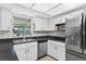 Bright kitchen featuring granite countertops, white cabinets, and stainless steel appliances at 35338 Lake Unity Rd, Fruitland Park, FL 34731