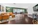 Open-concept living room with hardwood floors, green accent wall, and sectional sofa at 35338 Lake Unity Rd, Fruitland Park, FL 34731