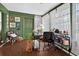 Bright home office with natural light, dark hardwood floors, and cheerful green walls at 35338 Lake Unity Rd, Fruitland Park, FL 34731