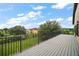 Spacious balcony with metal railing, overlooking lush green lawn and trees with a house in the background at 36914 Bee Meadow Ct, Eustis, FL 32736