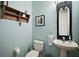 Charming half bathroom showcasing vintage mirror, decorative shelf, and calming blue walls at 36914 Bee Meadow Ct, Eustis, FL 32736
