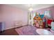 Bright bedroom with purple walls, a house-shaped toy and chandelier, perfect for a play area at 36914 Bee Meadow Ct, Eustis, FL 32736