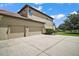 Spacious three-car garage with ample parking space and beautifully landscaped surroundings at 36914 Bee Meadow Ct, Eustis, FL 32736
