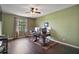Home office featuring a ceiling fan, hardwood floors, a desk and view out a window at 36914 Bee Meadow Ct, Eustis, FL 32736