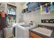 Bright laundry room with modern white appliances, shelving, and storage space, near a window for natural light at 36914 Bee Meadow Ct, Eustis, FL 32736