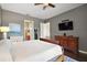 Comfortable bedroom with wood floors, a dresser, and an ensuite bathroom entrance at 36914 Bee Meadow Ct, Eustis, FL 32736