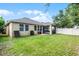 Spacious backyard with lush lawn, a covered patio, and a white picket fence at 418 Rock Springs Cir, Groveland, FL 34736