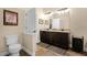 Bathroom with double vanity, toilet, decorative mirrors, and wood-look tile flooring at 418 Rock Springs Cir, Groveland, FL 34736