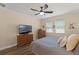 Well-lit bedroom with a ceiling fan, two windows, and a flatscreen TV at 418 Rock Springs Cir, Groveland, FL 34736