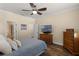 Spacious bedroom with a ceiling fan, ensuite bathroom, and a flatscreen TV at 418 Rock Springs Cir, Groveland, FL 34736