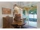 Cozy dining area with a round table, decorative saddle, and sliding glass doors to the outside patio at 418 Rock Springs Cir, Groveland, FL 34736