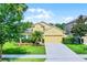 Charming single-Gathering home featuring a well-manicured lawn, mature trees, and a two-car garage at 418 Rock Springs Cir, Groveland, FL 34736