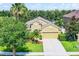 Attractive single-Gathering home with a lush front yard, mature trees, and a convenient two-car garage at 418 Rock Springs Cir, Groveland, FL 34736