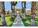 Elegant gated entrance to the community with a landscaped walkway and palm trees at 418 Rock Springs Cir, Groveland, FL 34736