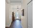 Bright hallway featuring wood-look tile, decorative wall art, and access to multiple rooms at 418 Rock Springs Cir, Groveland, FL 34736