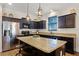 Modern kitchen with stainless steel appliances, granite countertops, and a center island with bar seating at 418 Rock Springs Cir, Groveland, FL 34736