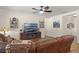 Spacious living room featuring a large sectional sofa, ceiling fan, and media center at 418 Rock Springs Cir, Groveland, FL 34736