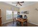 Bright home office with a wooden desk, two monitors, and natural light from the window at 418 Rock Springs Cir, Groveland, FL 34736