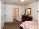 Well-lit bedroom featuring a dresser with mirror, and an adjacent bathroom with an open door at 5016 Mcdonald Rd, Zellwood, FL 32798