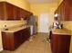 Traditional kitchen with wood cabinets, a stainless steel fridge, and tile flooring at 5016 Mcdonald Rd, Zellwood, FL 32798