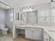 Bright bathroom featuring a granite countertop, double sinks, and neutral tile flooring at 591 Allenwood Loop, The Villages, FL 32162