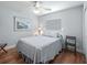 Comfortable bedroom with wood floors, a queen-size bed, ceiling fan, and a bright window at 591 Allenwood Loop, The Villages, FL 32162