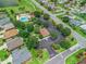 Aerial view of a community swimming pool surrounded by lush landscaping and mature trees near residences at 591 Allenwood Loop, The Villages, FL 32162