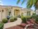 Charming home entrance with manicured bushes, a decorative fountain, and a tiled walkway at 591 Allenwood Loop, The Villages, FL 32162
