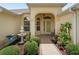 Inviting front entrance with a tiled walkway, decorative fountain, and lush landscaping at 591 Allenwood Loop, The Villages, FL 32162
