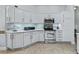 Bright kitchen boasts stainless steel appliances, light countertops, and white cabinets at 591 Allenwood Loop, The Villages, FL 32162