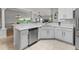 Stylish kitchen features stainless appliances, white countertops, and white cabinets at 591 Allenwood Loop, The Villages, FL 32162