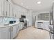 Bright kitchen features stainless appliances, light countertops, white cabinets and tile backsplash at 591 Allenwood Loop, The Villages, FL 32162