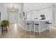 Open-concept kitchen featuring white cabinets, a breakfast bar with seating, and tile flooring at 591 Allenwood Loop, The Villages, FL 32162