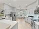 Bright kitchen featuring white cabinets, stainless steel appliances, and a breakfast nook with large windows at 591 Allenwood Loop, The Villages, FL 32162