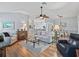 Open floor plan with living, dining, and kitchen areas, seamlessly connected by beautiful hardwood floors at 591 Allenwood Loop, The Villages, FL 32162