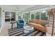 Bright living room with plush seating, stylish rug, and views of the lush outdoor greenery at 591 Allenwood Loop, The Villages, FL 32162